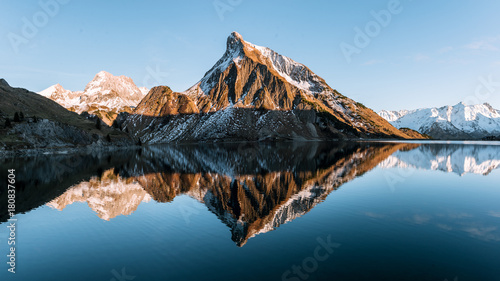 Sunset at a calm mountain lake in Austria with mirror-like reflection