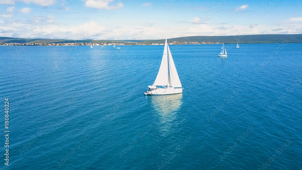 Obraz premium Aerial view of yacht sailing near beautiful Islands. Beautiful clouds in the background. Luxury yacht in the sea.