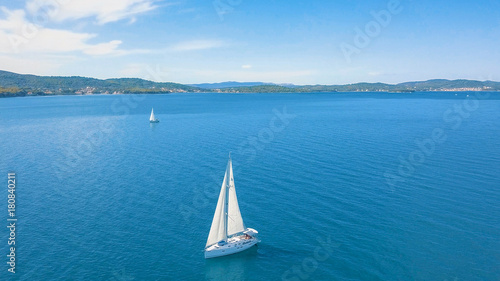 Aerial view of yacht sailing near beautiful Islands. Beautiful clouds in the background. Luxury yacht in the sea. © aerocaminua