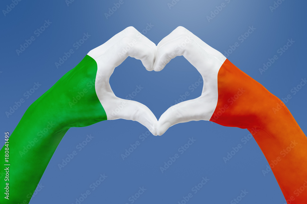 Hands flag of Ireland, shape a heart. Concept of country symbol, on blue sky. Hands flag of Ireland, shape a heart. Concept of country symbol, on blue sky.