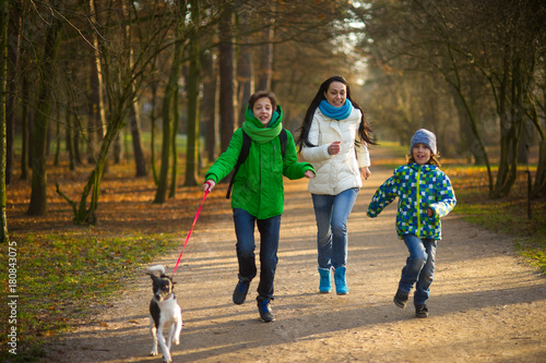Mother and two sons having fun in autumn Park.