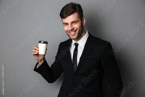 Young successful businessman enjoing his morning coffee, looking at camera photo