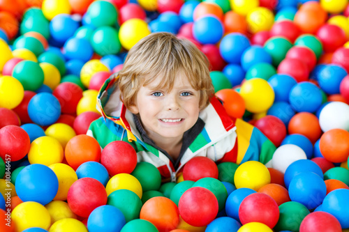 Little kid boy playing at colorful plastic balls playground © Irina Schmidt
