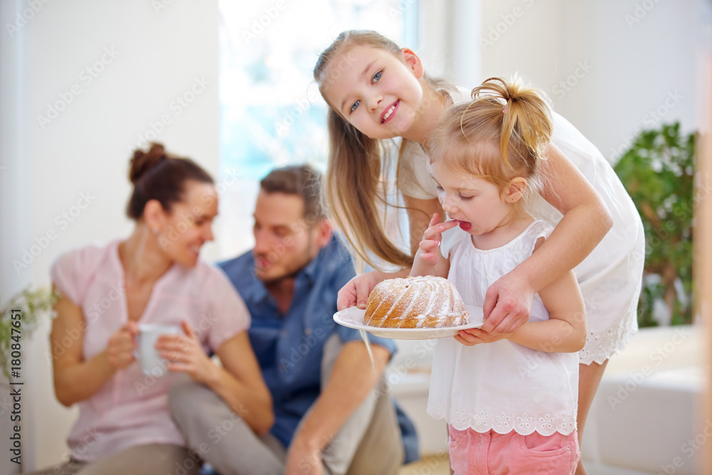 Familie mit Kuchen zu Hause im Wohnzimmer Familie mit Kuchen zu Hause im Wohnzimmer