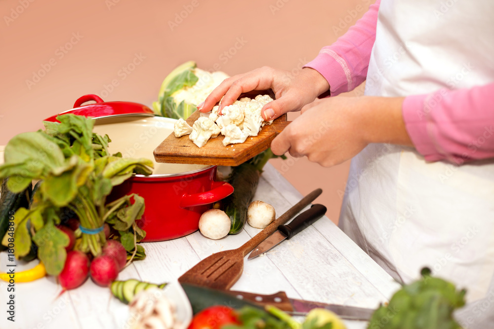 Woman preparing cauliflower fresh vegetable for cooking Woman preparing cauliflower fresh vegetable for cooking