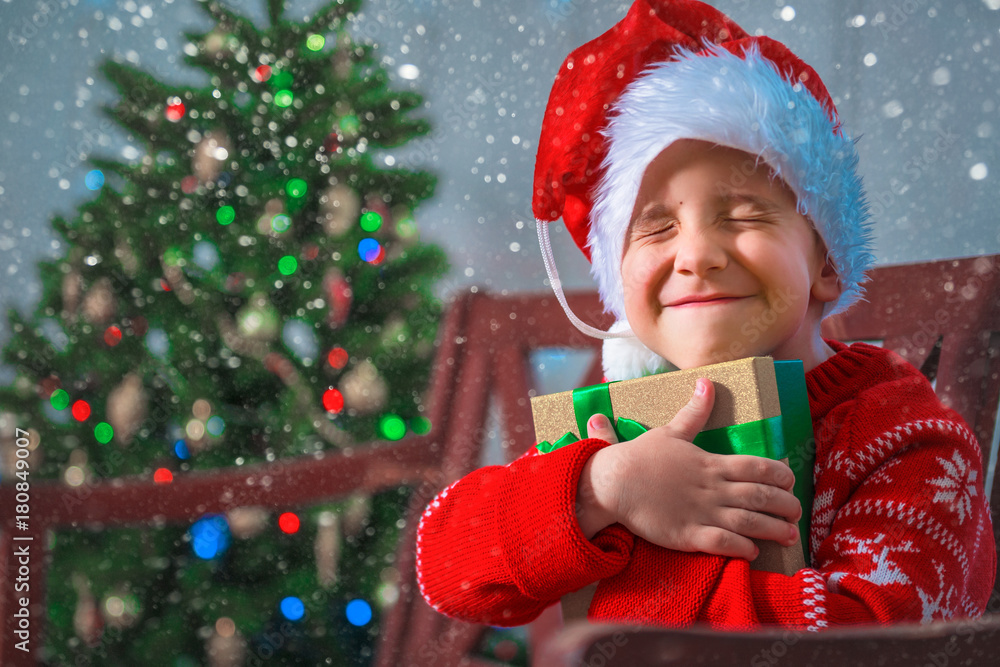 Portrait of a happy child with a gift on the background of a Christmas tree Portrait of a happy child with a gift on the background of a Christmas tree