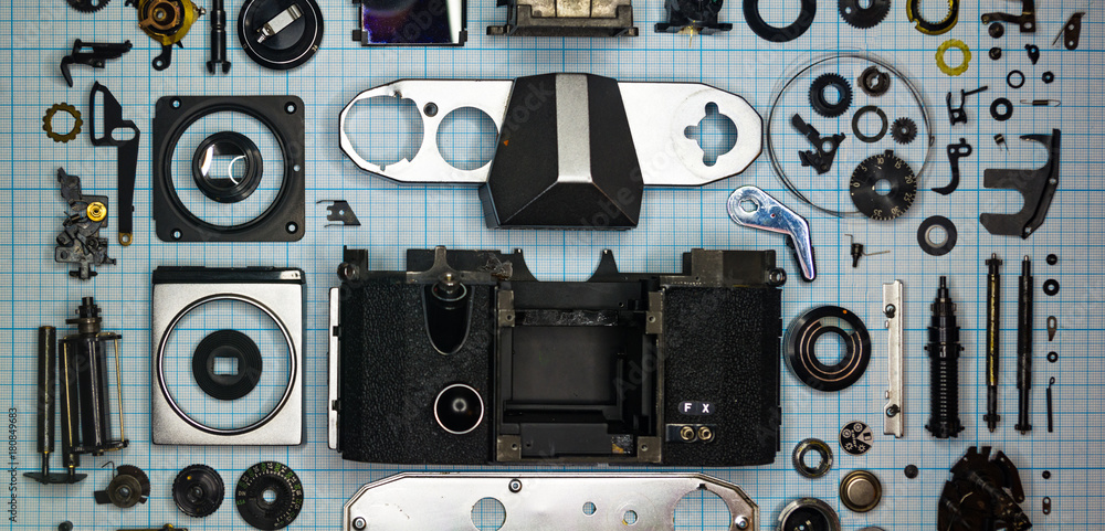 parts old retro film SLR camera on graph paper parts old retro film SLR camera on graph paper