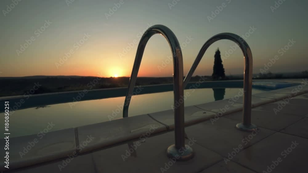 Swimming pool ladders, private outdoor poolside in summer evening Swimming pool ladders, private outdoor poolside in summer evening