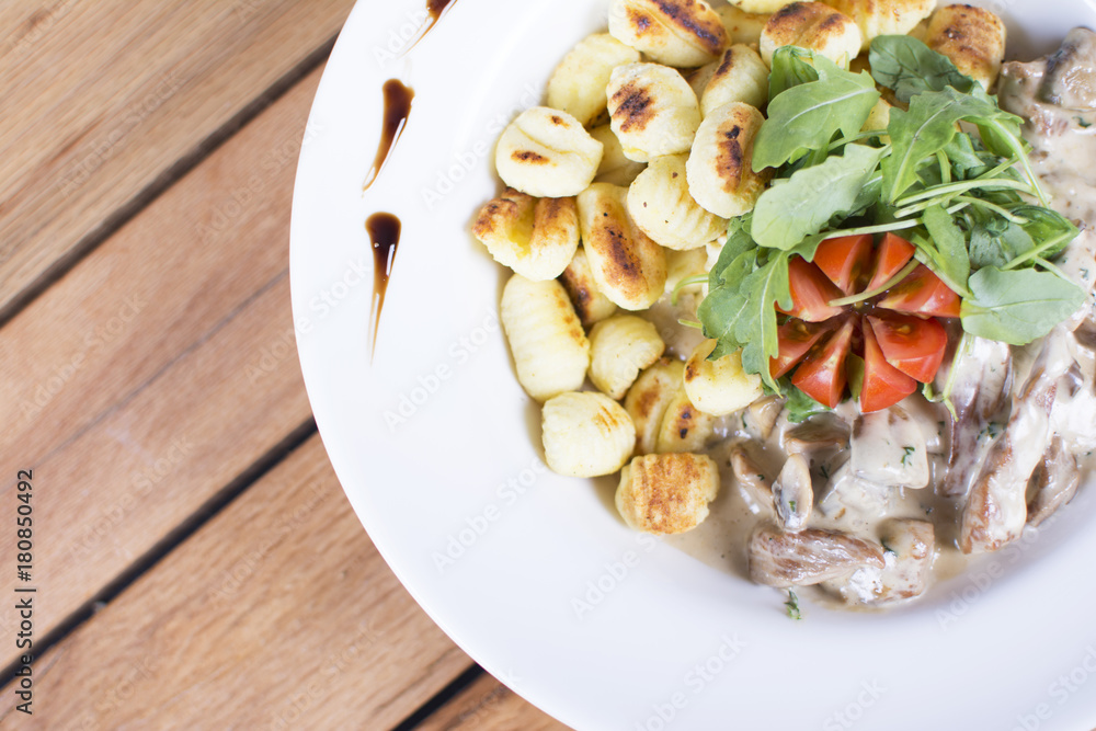 Nice meat with tomatoes with gnocchi. White cream topping with the touch of green seasoning. Beautifully served plate at the restaurant. Nice meat with tomatoes with gnocchi. White cream topping with the touch of green seasoning. Beautifully served plate at the restaurant.