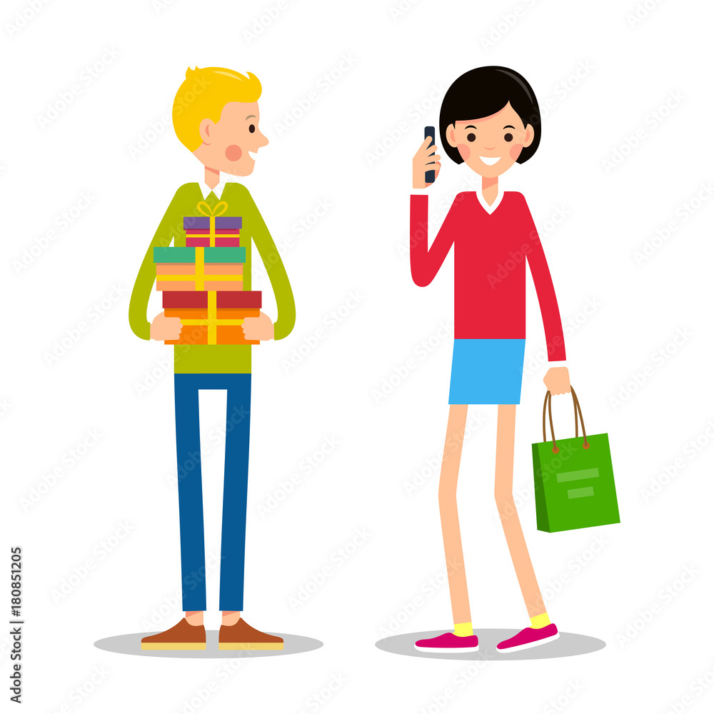 Young man is standing and holding several gift boxes. Young girl is standing next to shopping bag and talking on phone Young man is standing and holding several gift boxes. Young girl is standing next to shopping bag and talking on phone