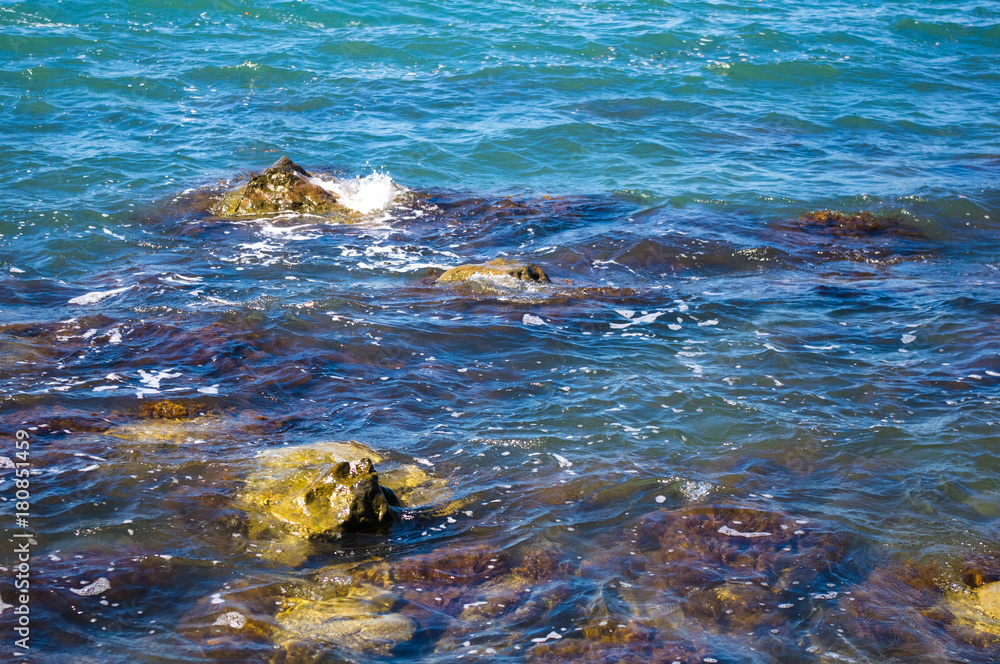 Fototapeta premium rocky sea shore with pebble beach, waves with foam
