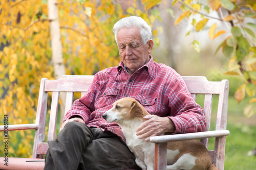 Old man with dog on bench in park