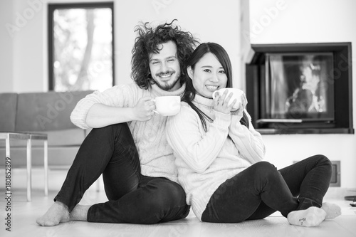 happy multiethnic couple in front of fireplace