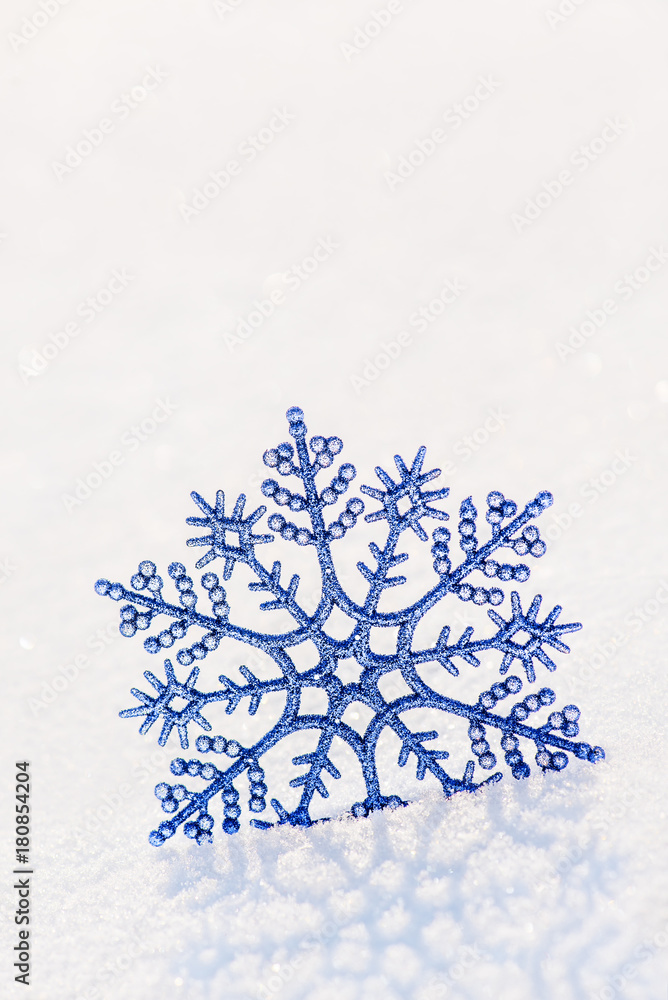 Shiny blue snowflake on brilliant snow, winter Christmas concept background Shiny blue snowflake on brilliant snow, winter Christmas concept background
