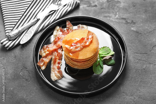 Tasty pancakes with bacon on plate