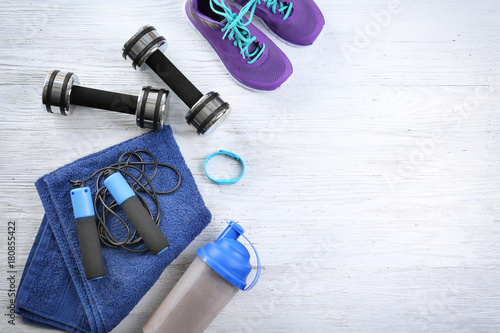Composition with towel and sport equipment on wooden background