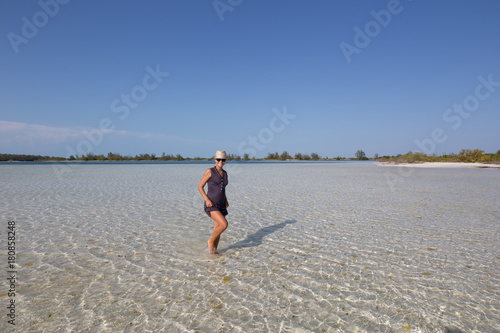 Girl walking in the water on the most beautiful beach of Cuba