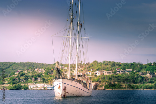 Man working on his mast - sailboat in a bay of Cuba