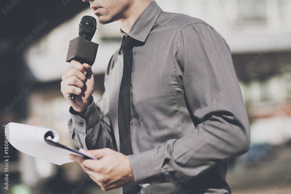 © VadimGuzhva - The journalist speaks into the microphone, and holds the holder for the sheets