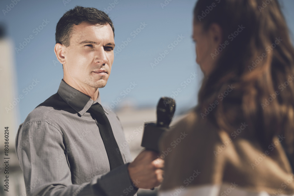 A man with a serious face interviews a woman A man with a serious face interviews a woman