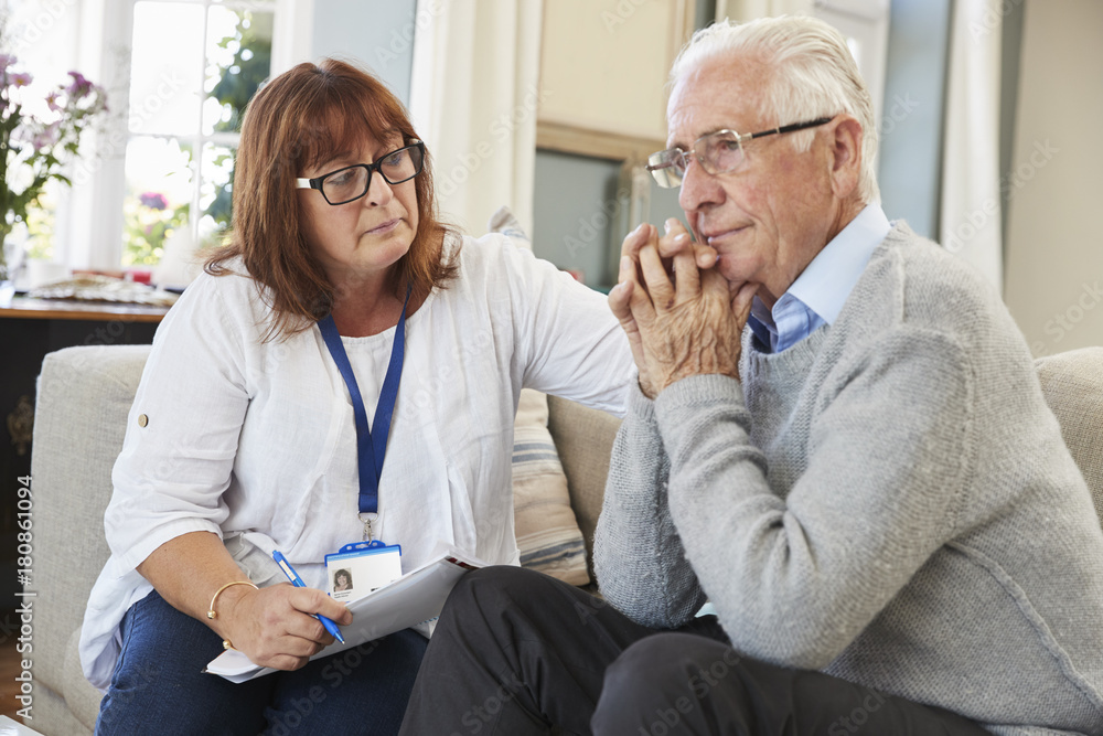 Obraz premium Support Worker Visits Senior Man Suffering With Depression