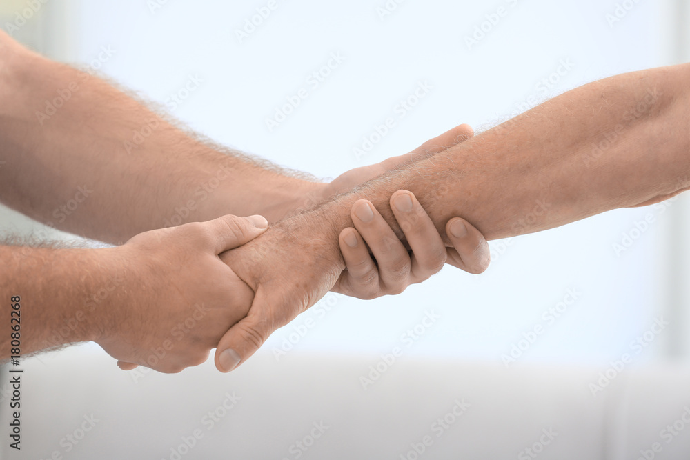 Physiotherapist giving senior man hand massage in clinic Physiotherapist giving senior man hand massage in clinic