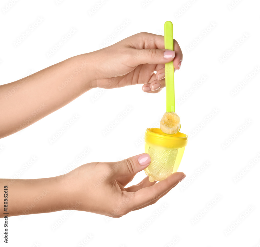 Woman filling baby's nibbler on white background Woman filling baby's nibbler on white background