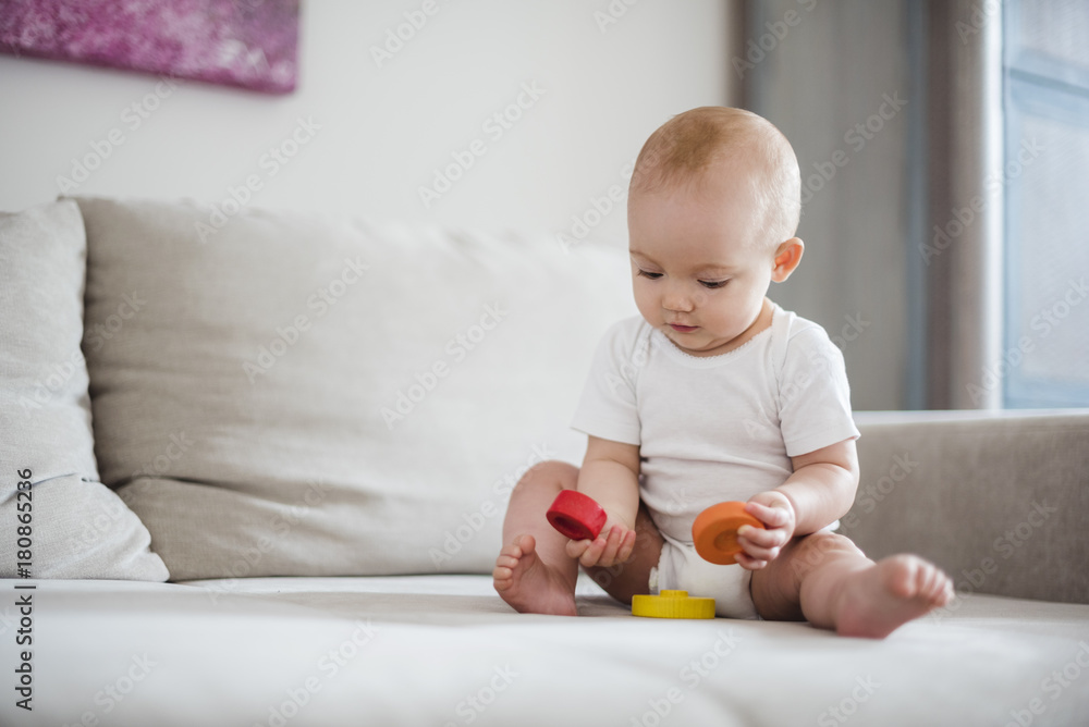 Baby girl playing on couch at home Baby girl playing on couch at home