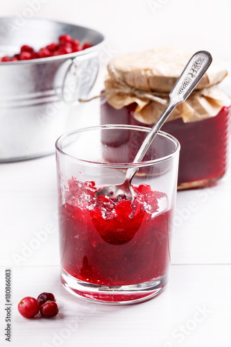 Red cranberry jam in glass on white table