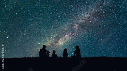 The family sit on stars fall background. night time, time lapse