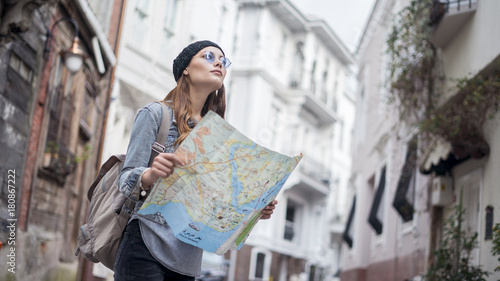 Young tourist woman hand map in outdoors photo