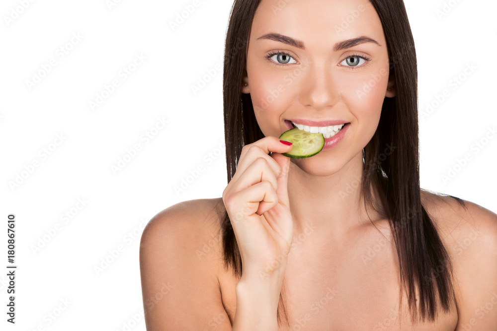woman biting slice of cucumber woman biting slice of cucumber