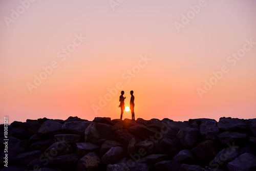 a man and a woman on sunset background