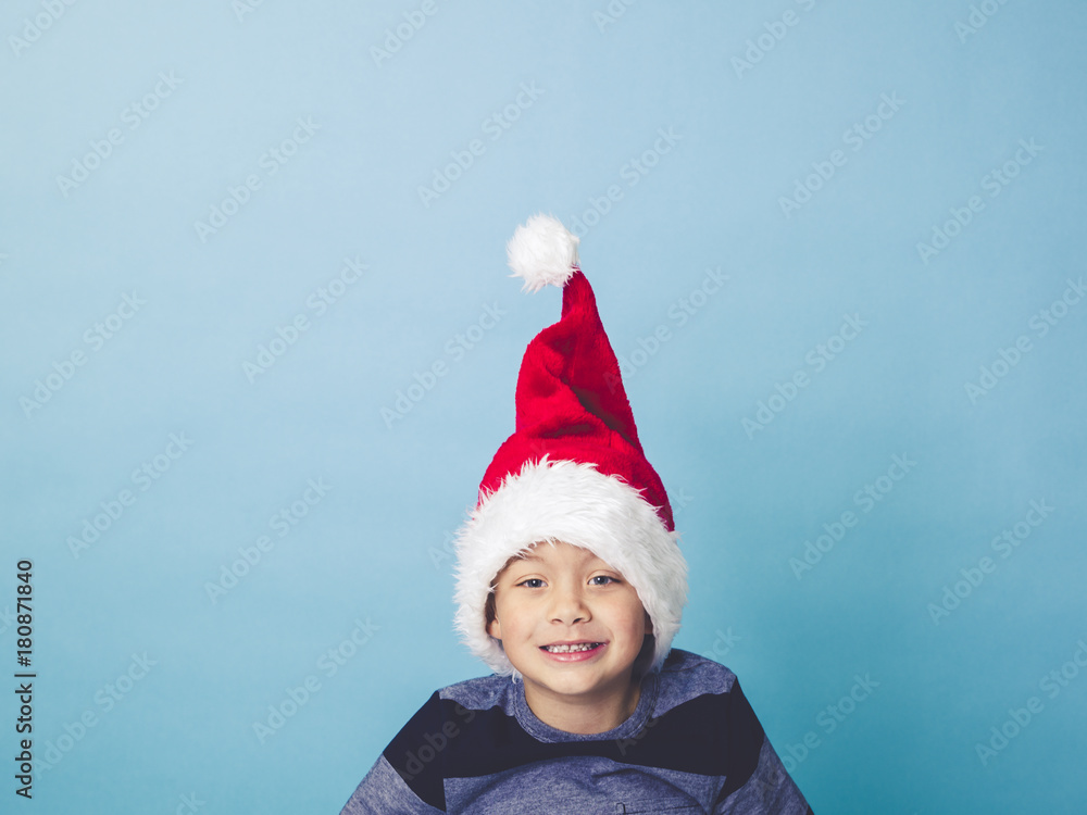 young 5 year old boy with christmas decoration on his hat young 5 year old boy with christmas decoration on his hat