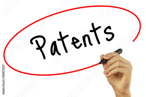 Man Hand writing Patents with black marker on visual screen. Isolated on background. Business, technology, internet concept. Stock Photo