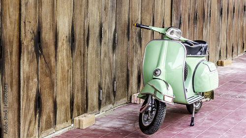 Fotografie Green scooter against old house