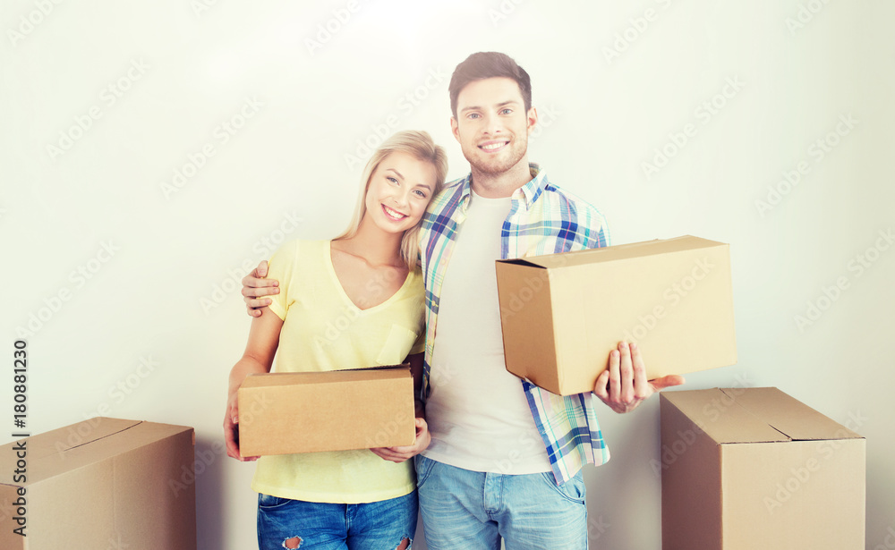 smiling couple with big boxes moving to new home smiling couple with big boxes moving to new home