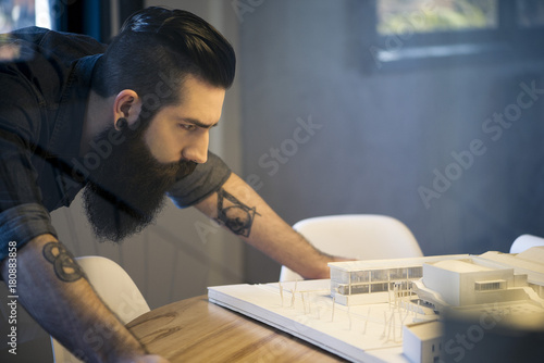 Man looking at model building in office