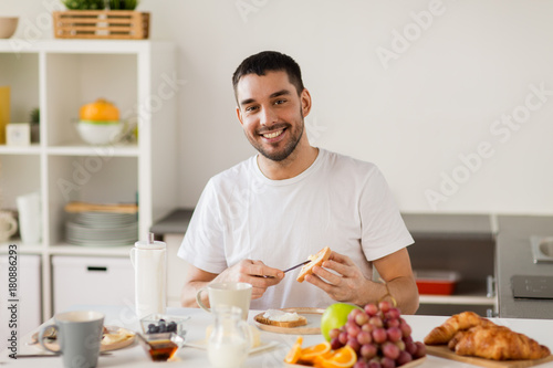 man eating toast with coffee at home kitchen