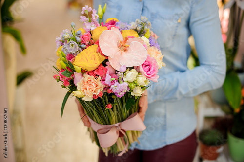Florist holding a beautiful colorful bouquet of flowers with a cute bow