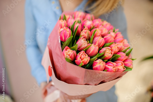 Woman holding a beautiful and tender bouquet of pink tulips