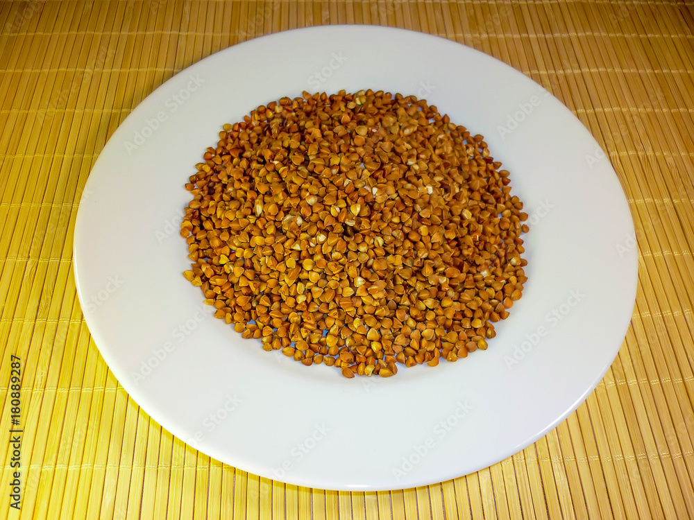 buckwheat in a white plate on a light background buckwheat in a white plate on a light background