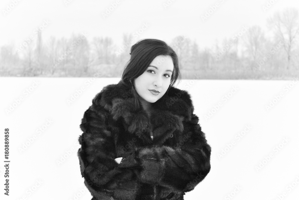Plus size nice young lady in retro look style walk at winter time wear in not natural fur coat. Woman have a good mood. Winter holiday time, black and white photo Plus size nice young lady in retro look style walk at winter time wear in not natural fur coat. Woman have a good mood. Winter holiday time, black and white photo