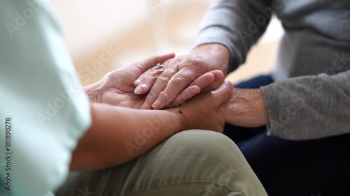 Closeup of nurse holding old woman hands