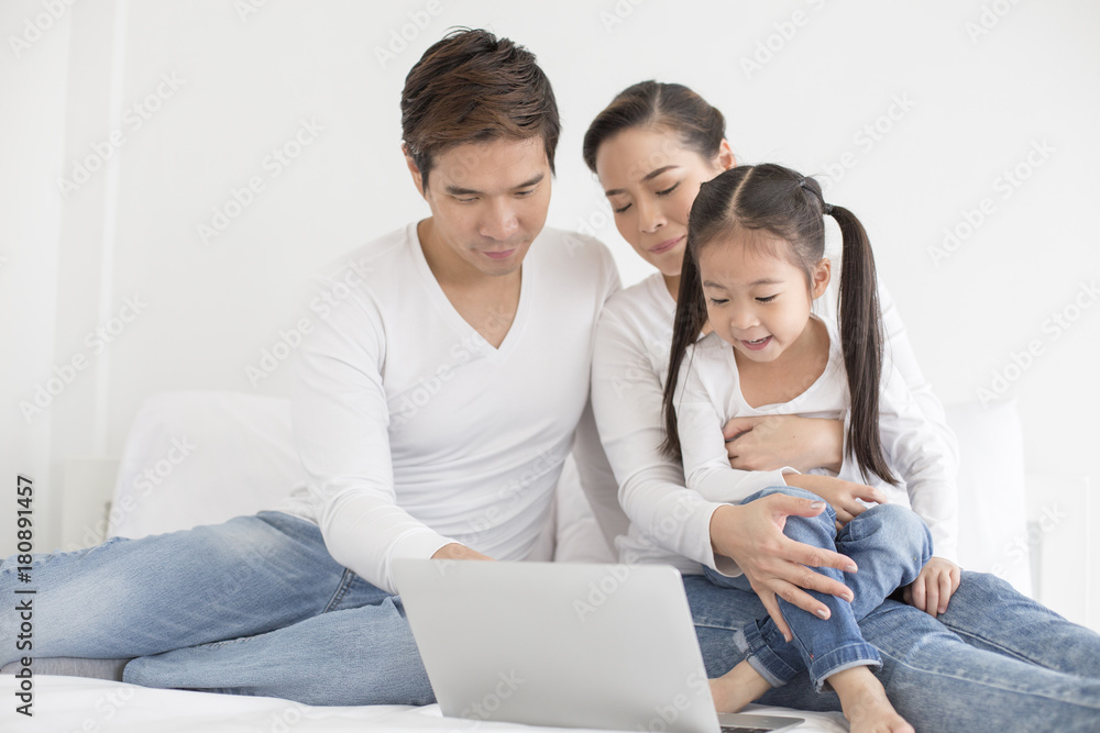 Attractive Little Girl using Laptop with Mom and Dad Together. Girl learning to use Laptop. Happy Family Concept. Attractive Little Girl using Laptop with Mom and Dad Together. Girl learning to use Laptop. Happy Family Concept.