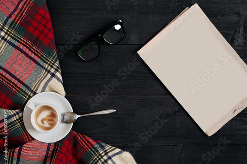 Workspace with newspaper, coffee cup, scarf, glasses. Stylish office desk. Autumn or Winter concept. Flat lay, top view