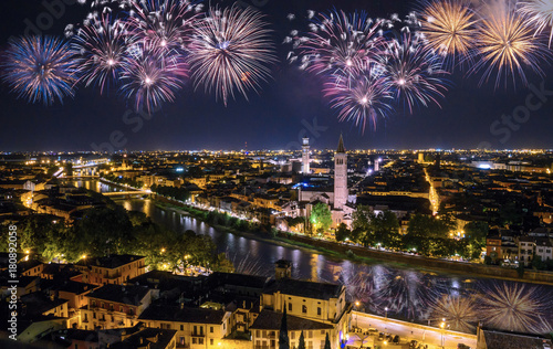 Beautiful night aerial view of Verona with fireworks on the black sky, Veneto region, Italy. 