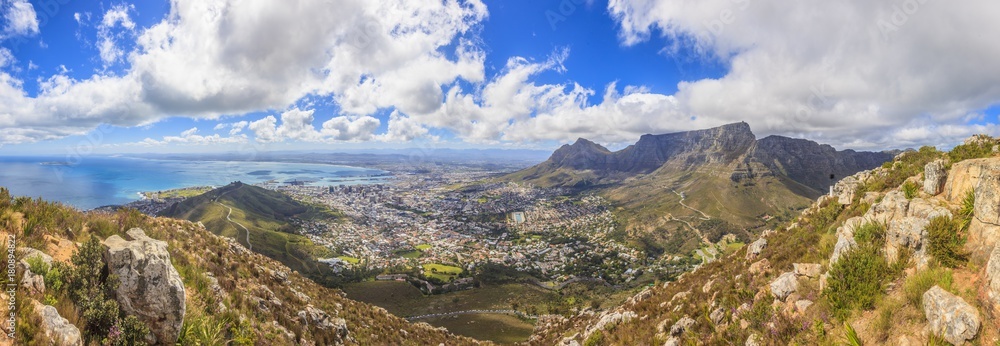 Fototapeta premium Panoramaaufnahme von Kapstadt und Tafelberg sowie Signal Hillaufgenommen vom Lions Head tagsüber bei blauem Himmel mit einigen weißen Wolken fotografiert in Südfrika im September 2013