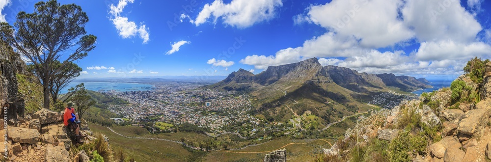 Panorama Aufnahme von Kapstadt und Tafelberg beim Aufstieg zum Lions Head fotografiert tagsüber bei blauem Himmel mit einigen Wolken in Südafrika im September 2013