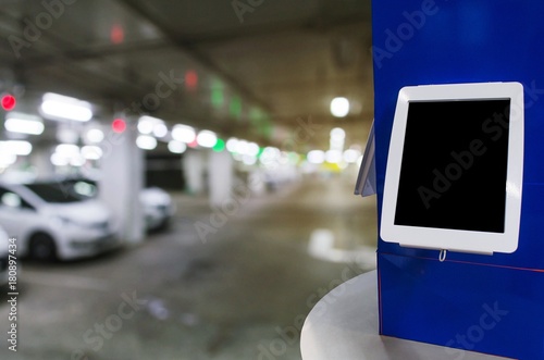 Wallpaper Mural blank digital monitor or tablet on desk at intelligent technology car parking garage area at department store or shopping mall, copy space for text or media content, marketing, advertisement concept Torontodigital.ca